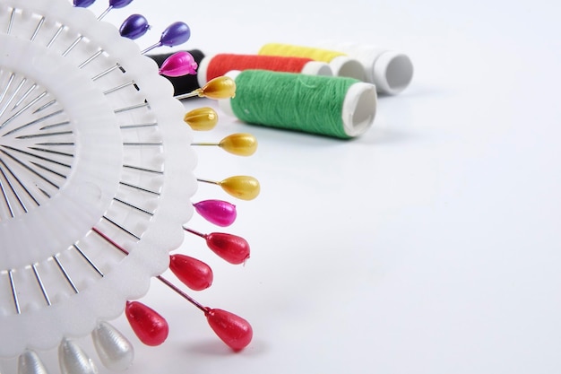 Igła i kolorowe nici na tle płótna